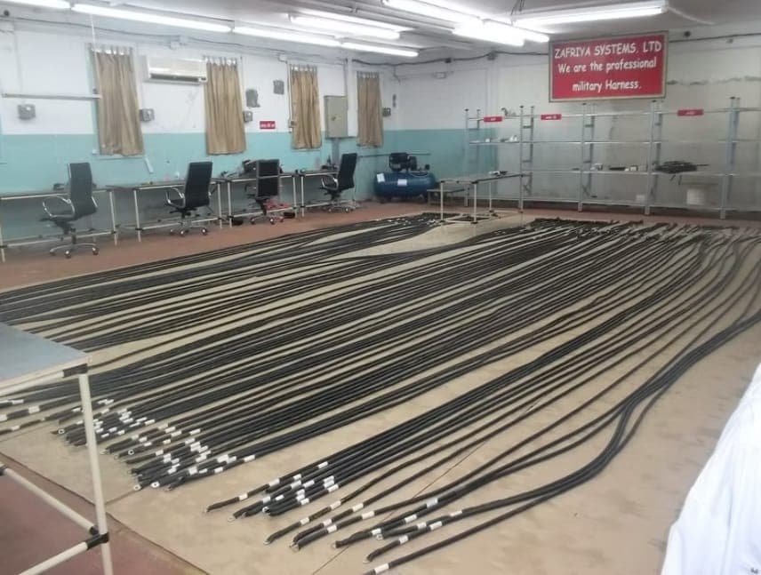 Long cable assemblies laid out the full length of the production hall, each terminated and labelled.